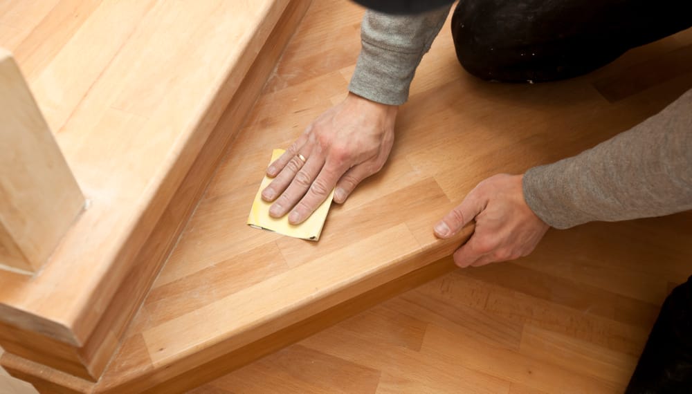 Using sandpaper to remove deep scratches from wooden floors