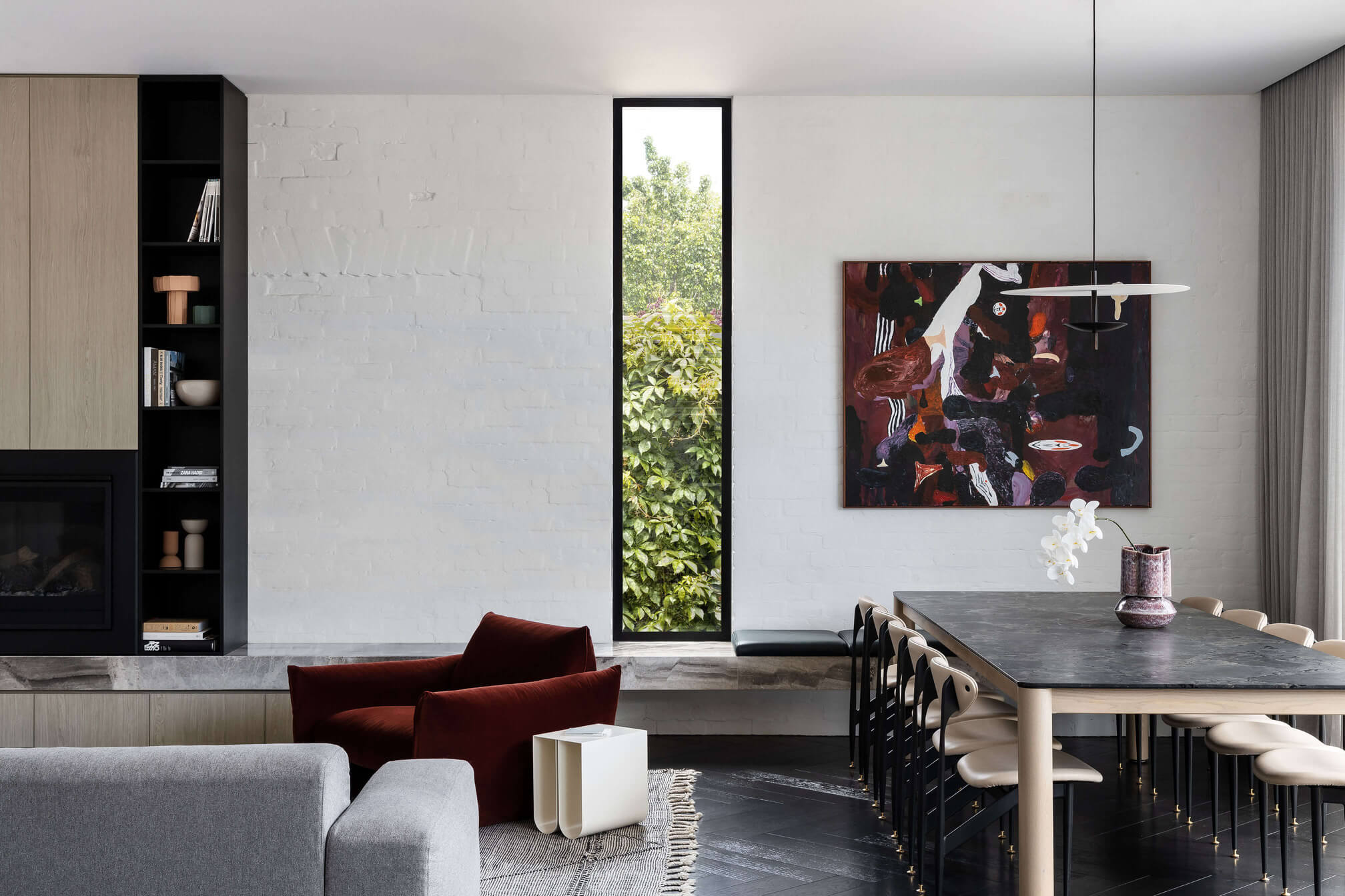 Dark floors with matching timber chairs on a white walled house