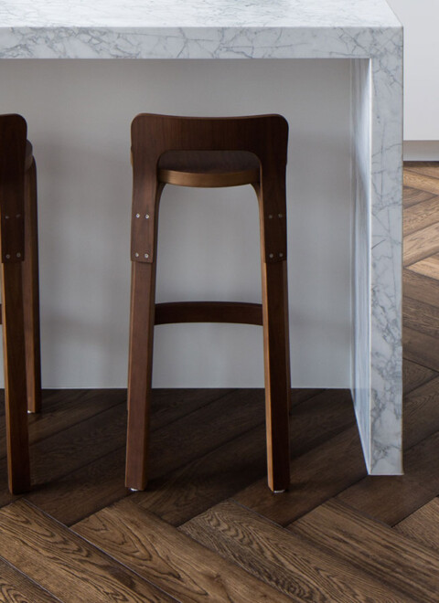 Carrara marble waterfall bench with walnut stools on walnut herringbone oak floor