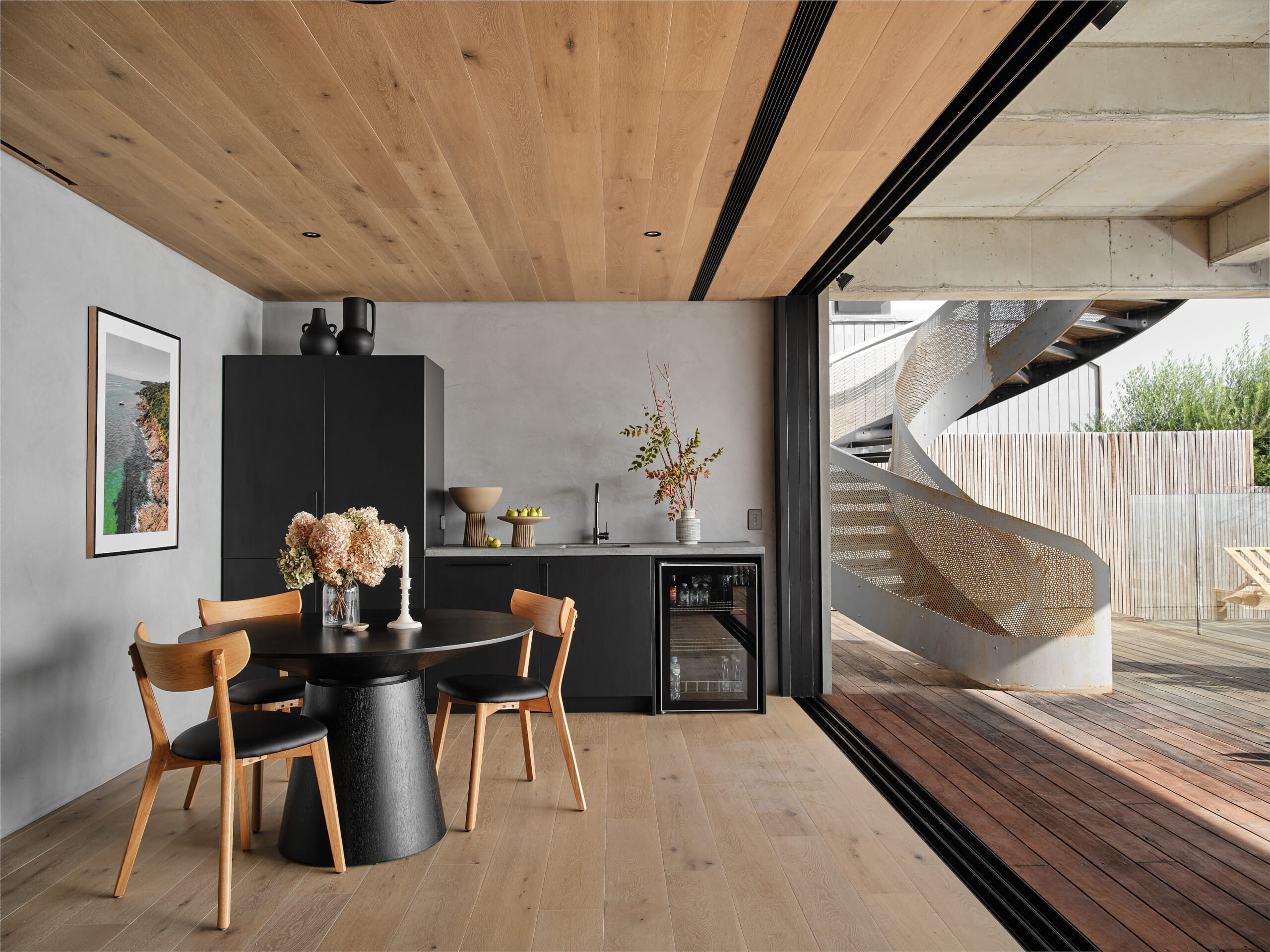 Modern dining and kitchenette space featuring light engineered timber flooring and matching timber ceiling