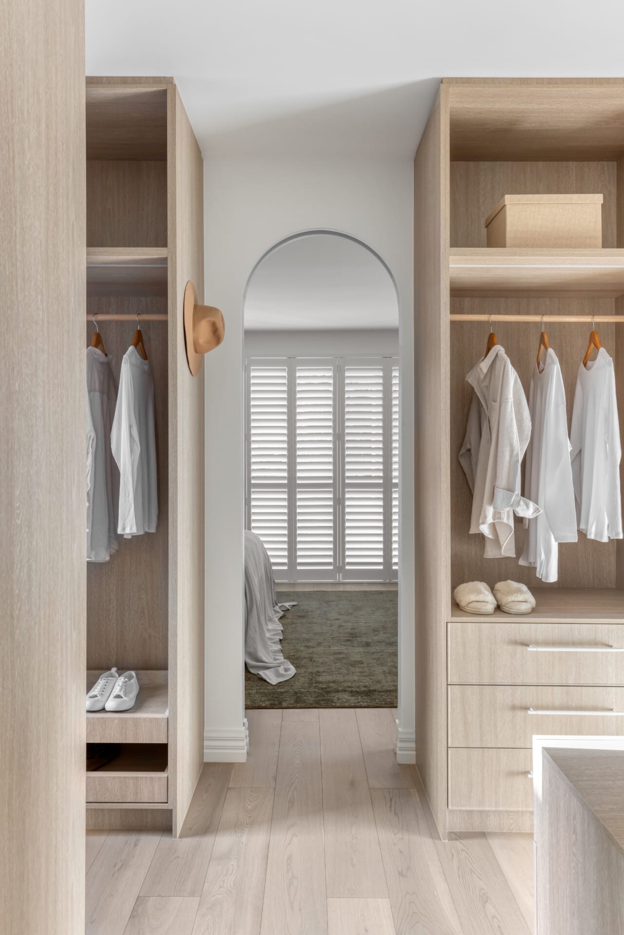 Light timber walk-in wardrobe with open shelving