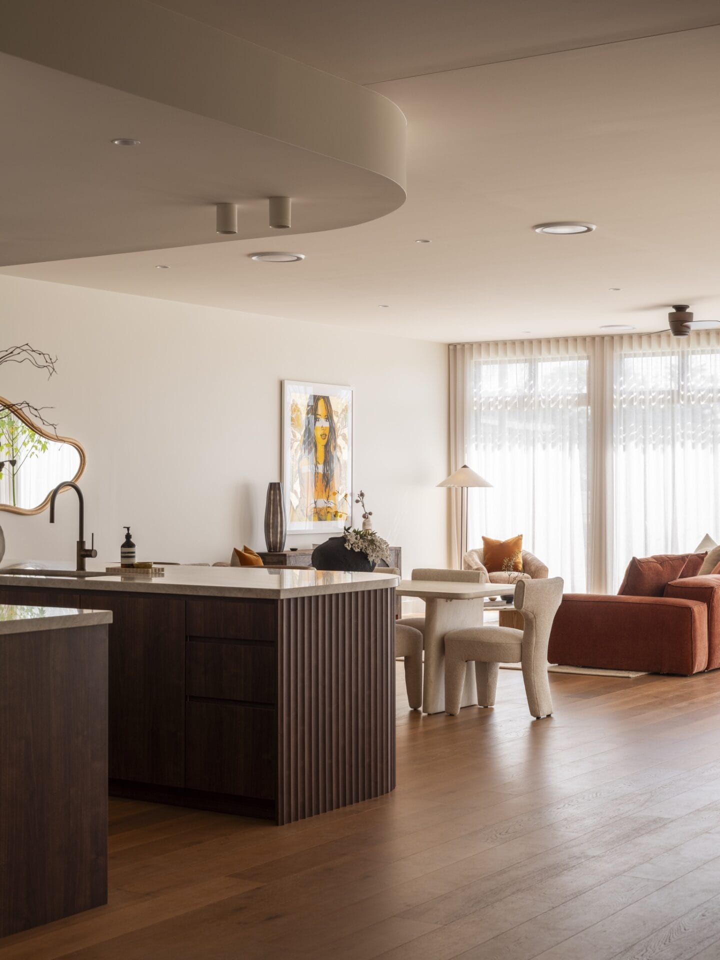 Open-plan living and dining at MARÈA beneath a curved bulkhead, with Dakar oak flooring