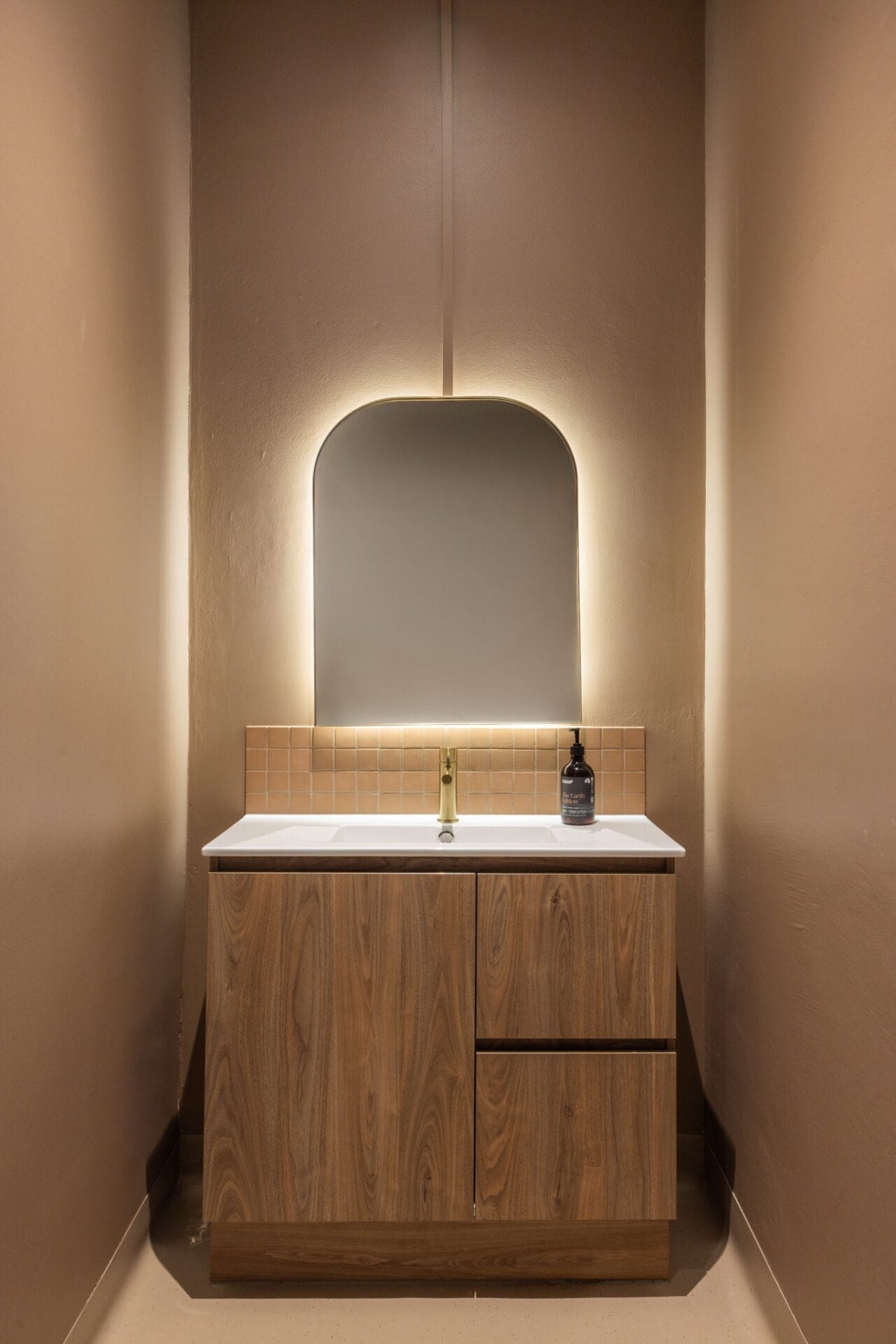 Arched niche in textured render lit by concealed cove lighting