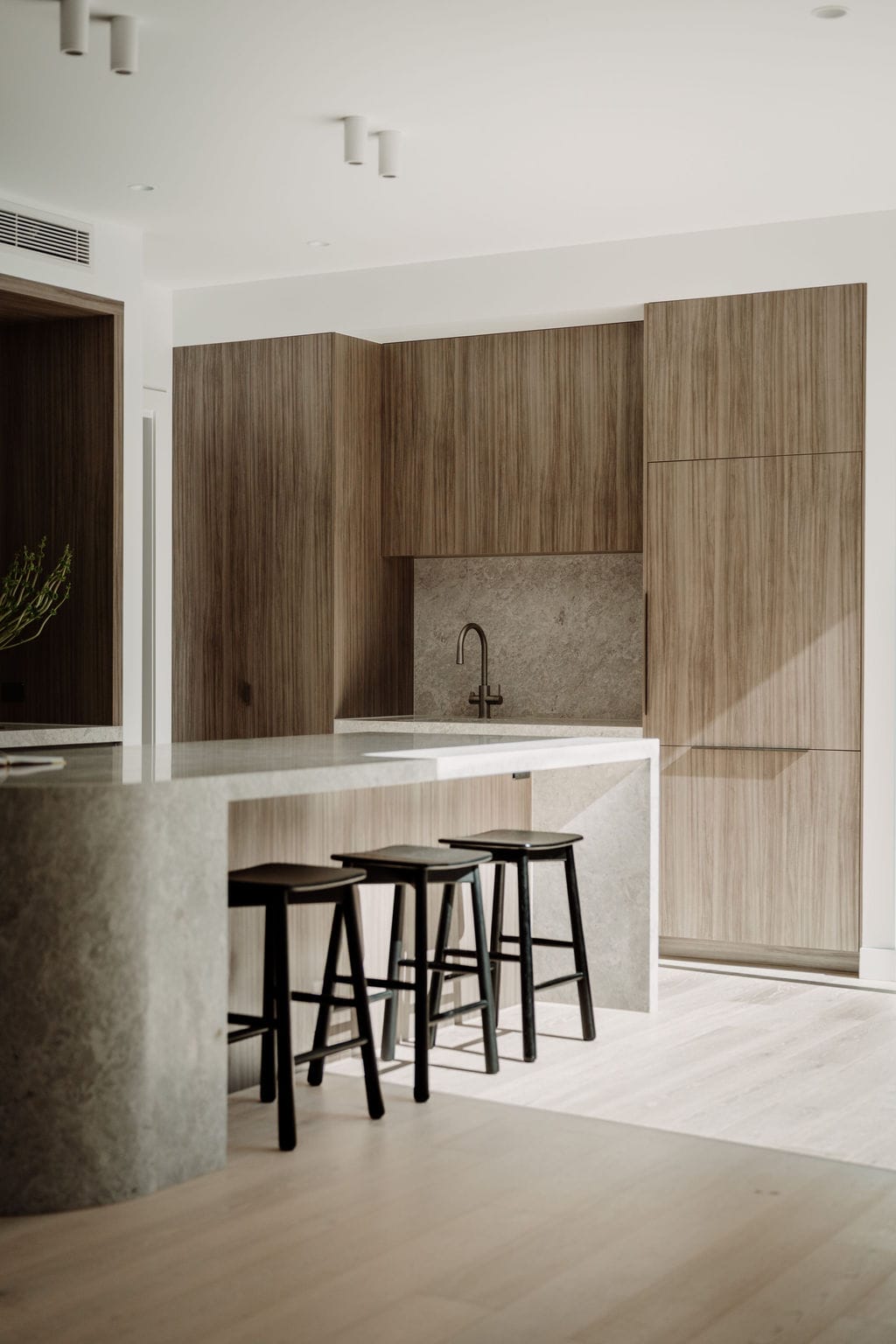 Scullery with timber joinery, a stone splashback and brass tapware