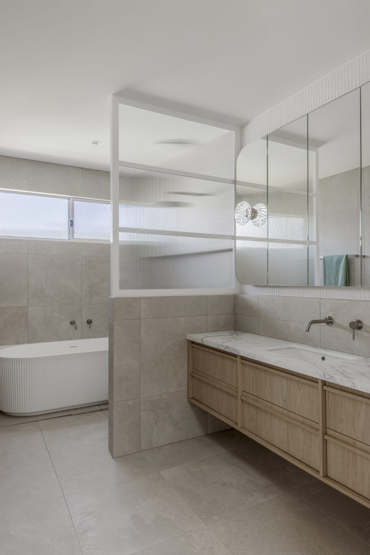 Ensuite with a fluted glass shower screen and full-height mirror