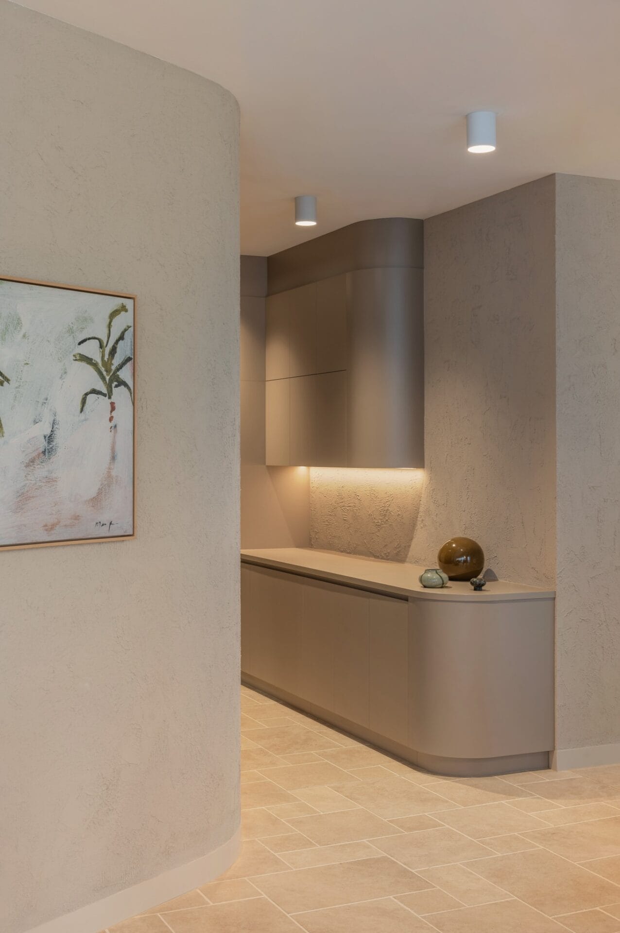 Framed artwork and a cove-lit display niche set into a curved rendered wall