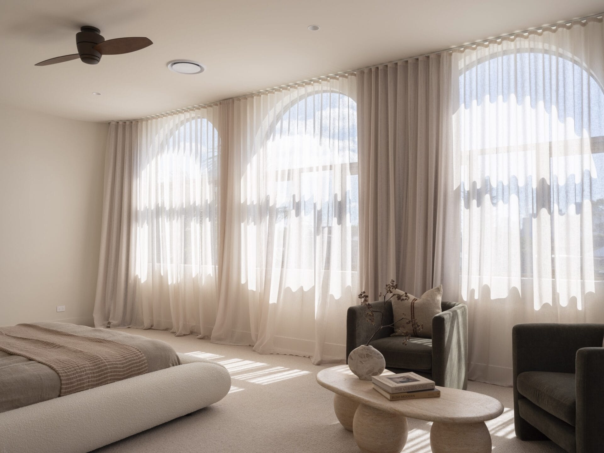 Retreat at MARÈA with arched windows, sheer curtains and curved sofa