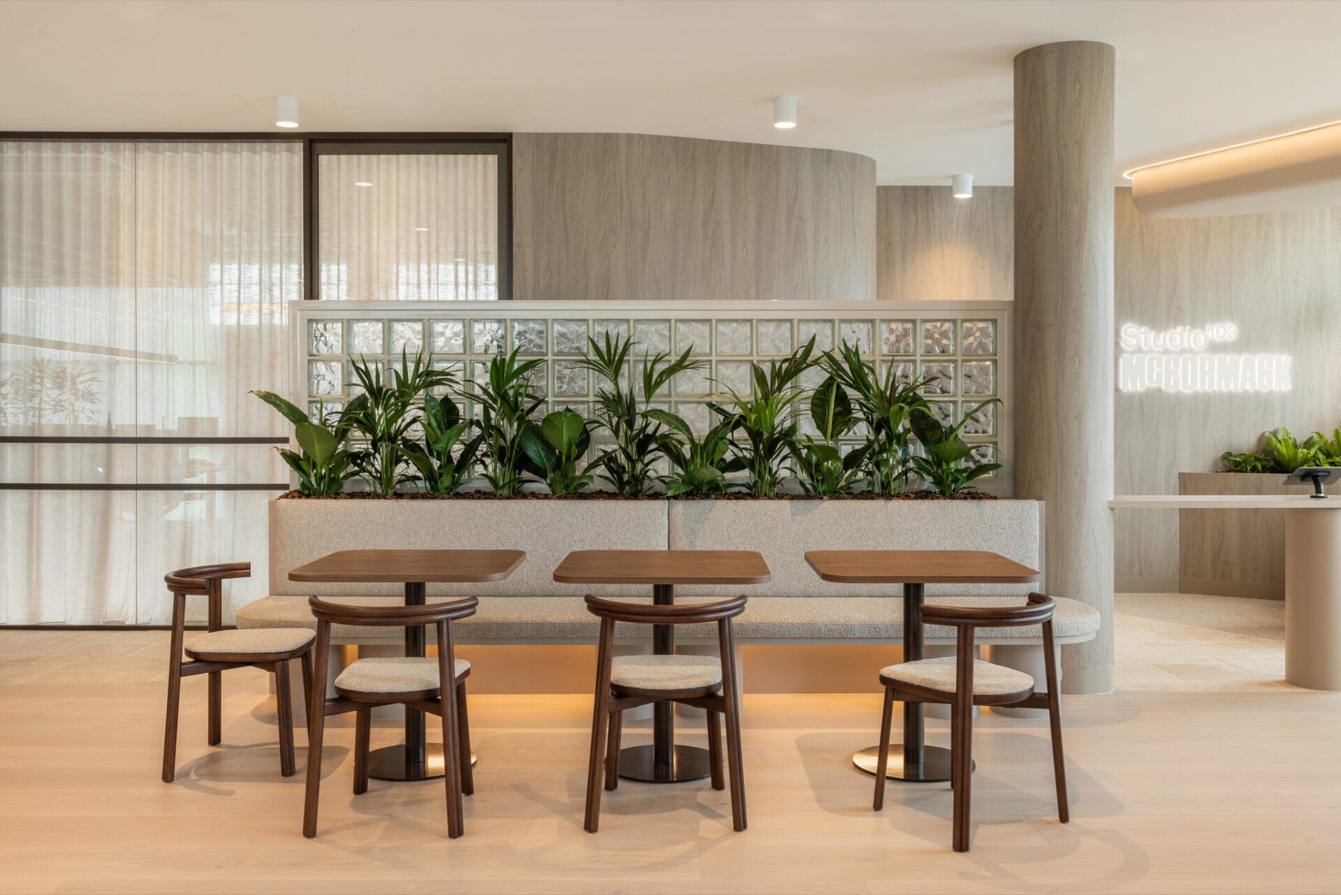 Bar bench and stools in the breakout area, with a glass block wall separating it from the boardroom