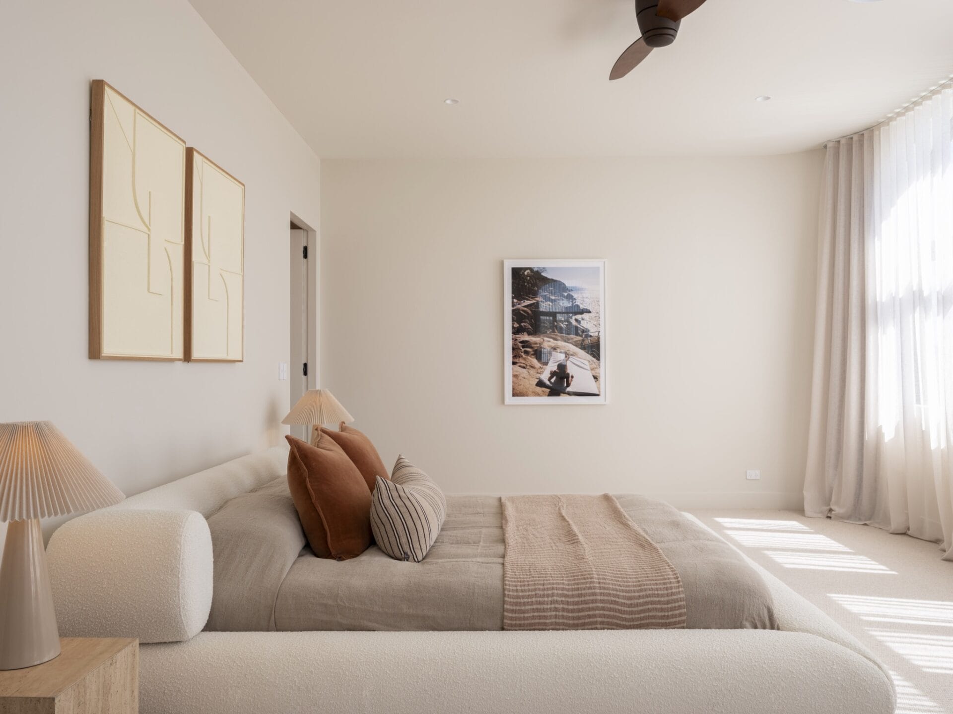 Bedroom at MARÈA with layered neutral bedding and sheer curtains