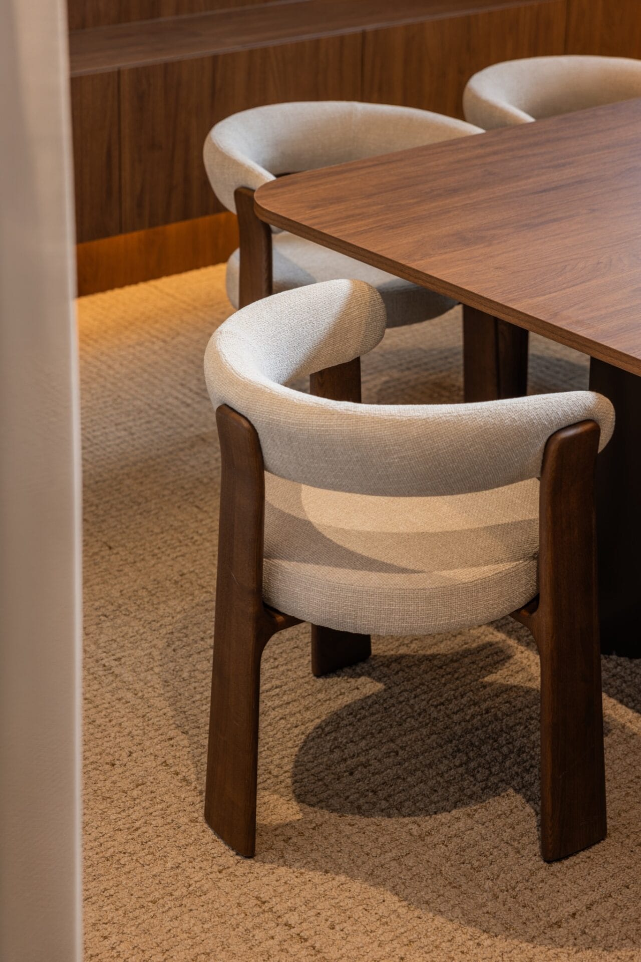 Curved cream chairs tucked beneath a solid timber boardroom table