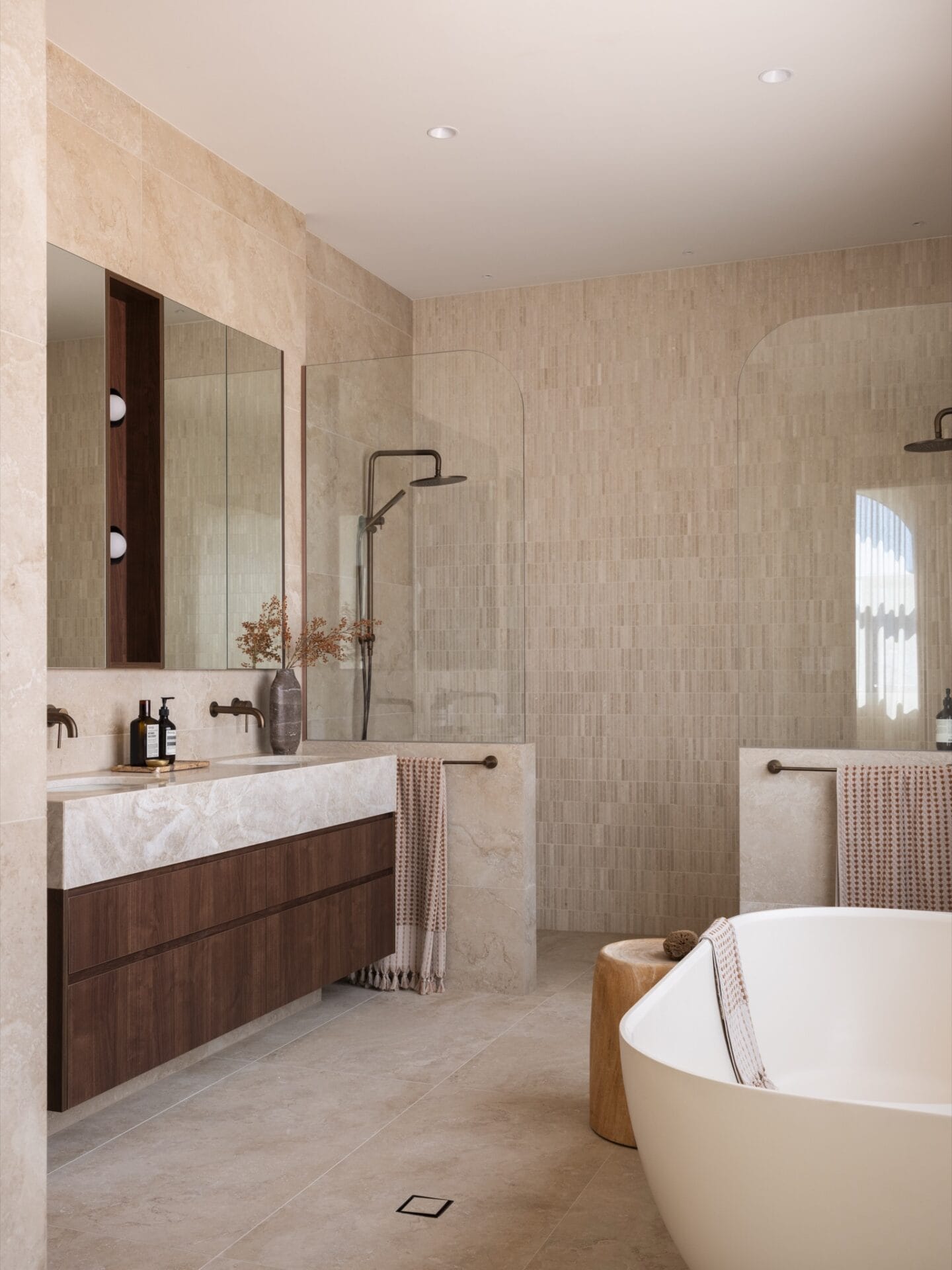 Main ensuite with freestanding bath, double shower, and walnut vanity