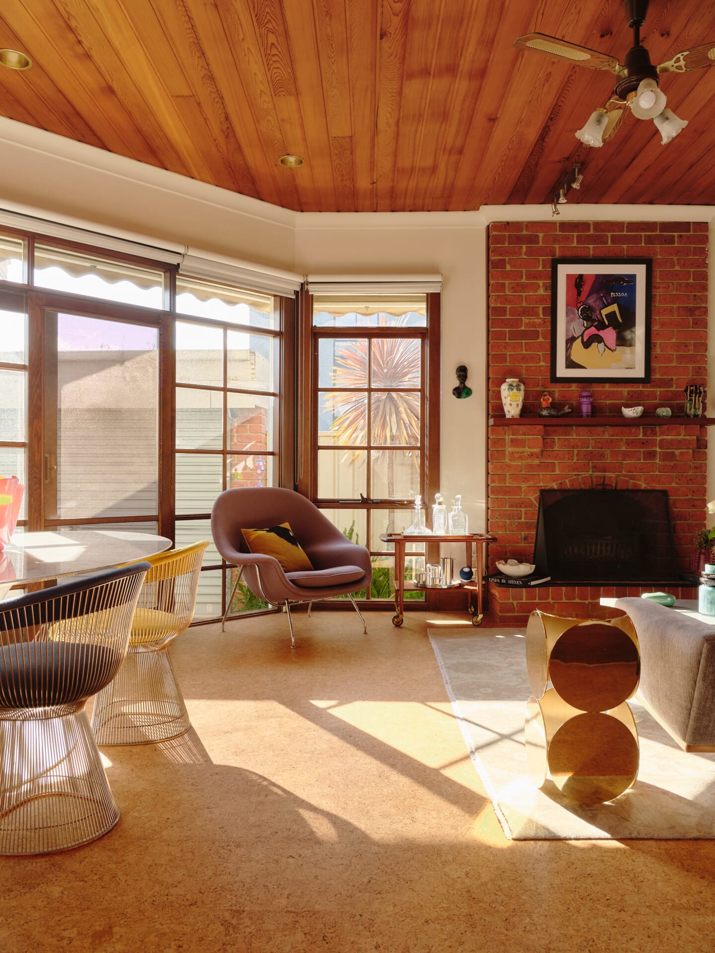 Living and dining area with a timber-panelled ceiling and brick fireplace, Porto cork flooring running throughout.