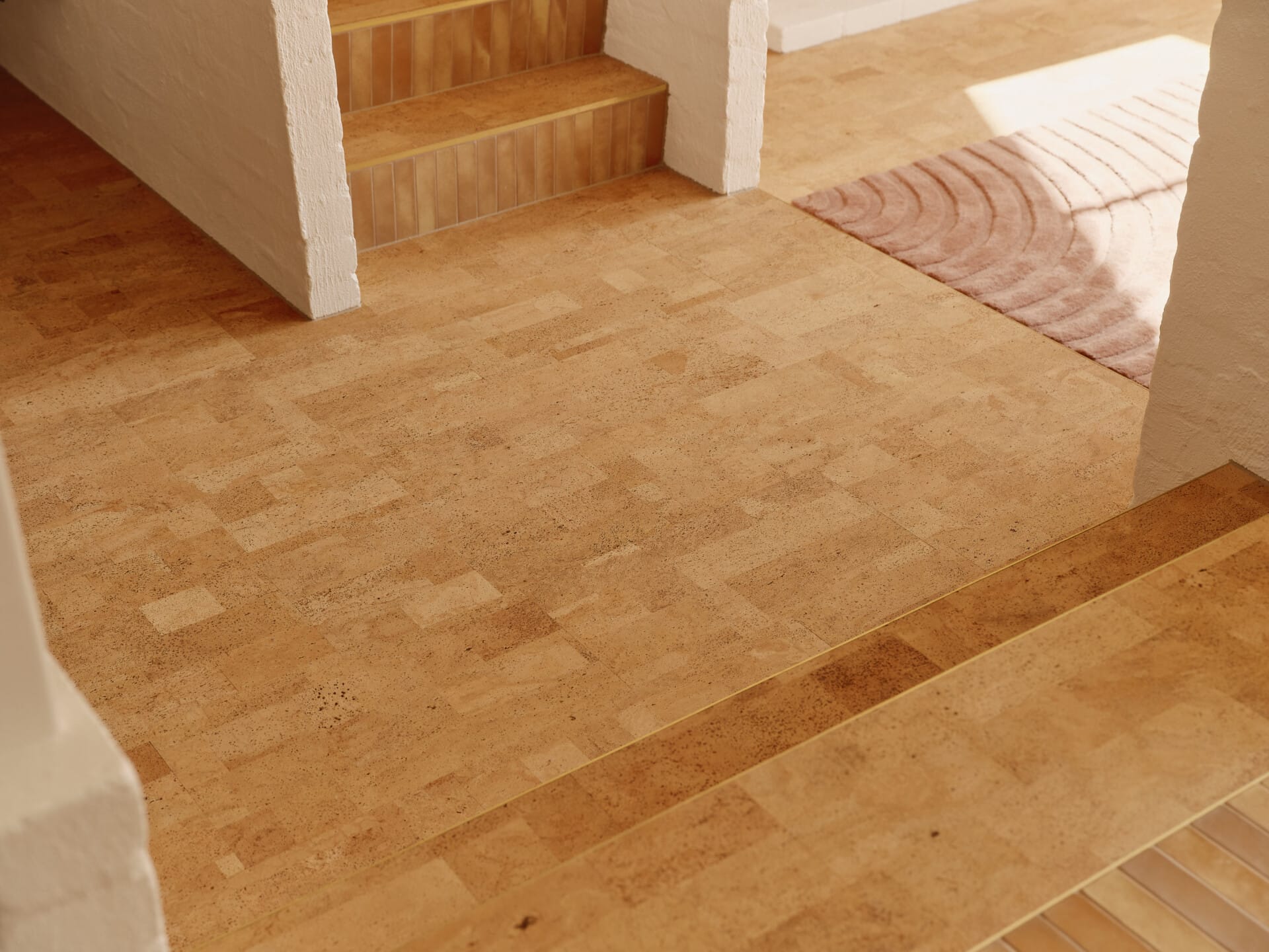 Close-up of Lisbon cork tiled flooring at the base of a staircase, sunlight catching a striped rug in the doorway beyond.