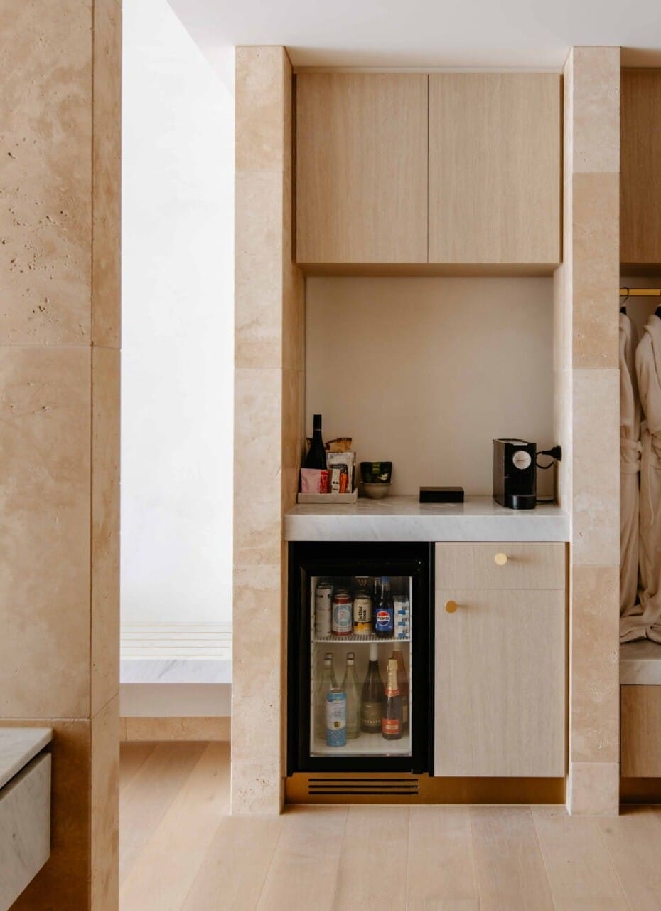 Hotel Sorrento guest suite mini bar nook with travertine-clad joinery, floored in Kustom Timber Habitat Calypso 190mm engineered oak.