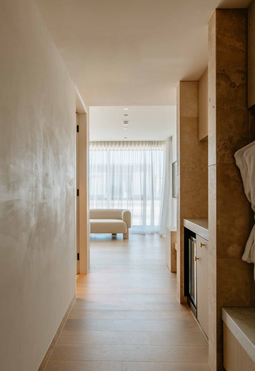 Hotel Sorrento guest suite hallway floored in Kustom Timber Habitat Calypso 190mm engineered oak, leading to a sitting area with sheer curtains and coastal light.